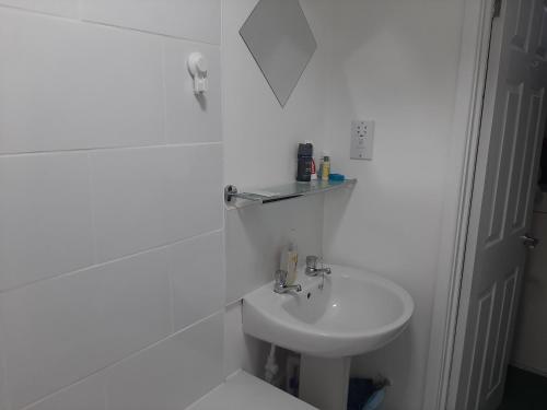 a white bathroom with a sink and a toilet at Newport Ensuite Sleeps 2 near Train Station in Newport