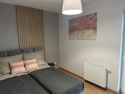 a bedroom with a bed and a painting on the wall at PB EasyStay in Szczytno