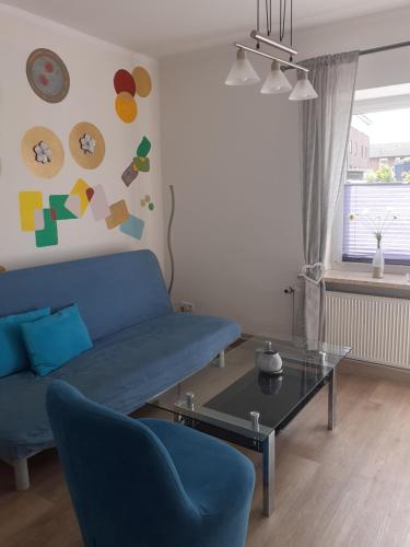 a living room with a blue couch and a table at Ferienwohnung Busdorf in Busdorf