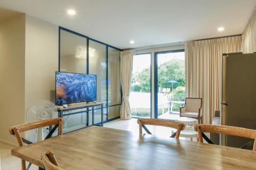 a dining room with a table and a television at Beach Front Condo, Baan Thew Talay, Perfect Choice for Family and Couple in Ban Bo Khaem