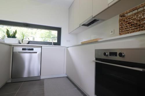 a kitchen with stainless steel appliances and a window at Quinta do Chão do Vale in Sever do Vouga