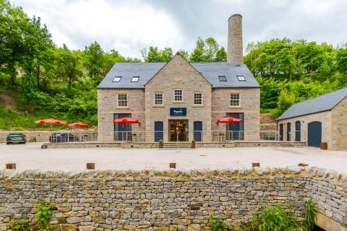 a stone building with red umbrellas in front of it at No.6 - Studio Apartment with Private Terrace in Stoney Middleton