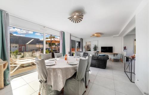 une salle à manger avec une table et un salon dans l'établissement Amazing Home In Saint-Méloir-Des-Ondes, à Saint-Méloir-des-Ondes