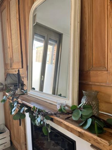 - un miroir au-dessus d'une cheminée dans la chambre dans l'établissement Charmante amiénoise proche gare, à Amiens
