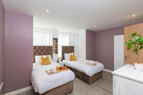 a bedroom with two beds with towels on them at The Phantom Apartment 1 minute walk to JR, Churchill Manor Nuffield Hospitals Oxford B Uni, Sleeps 5 Guests comfortably very modern 2 rooms 3 bathrooms Private Garden in Oxford