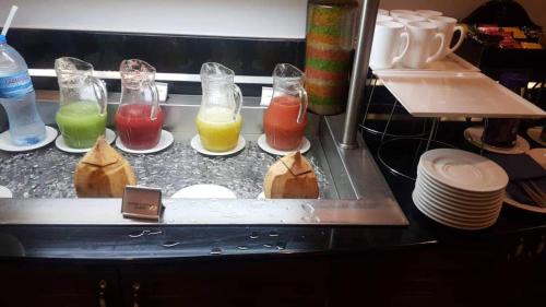 a counter with different types of drinks in glass containers at Protea Hotel by Marriott Dar es Salaam Courtyard in Dar es Salaam