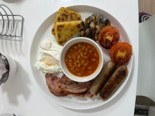 a plate of food with eggs sausage beans and toast at Trivelles Gatwick Hotel & airport Parking in Crawley