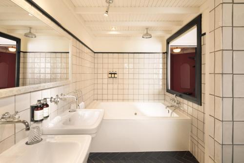 a white bathroom with a tub and a sink at La França Travellers Adults Only in Barcelona