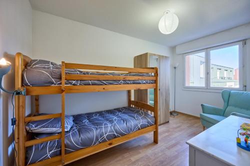 a bedroom with bunk beds and a living room at Le Côtier - Appt à 200m de la plage in Courseulles-sur-Mer