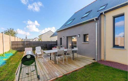 a backyard with a wooden deck with a table and chairs at Amazing Home In Saint-Méloir-Des-Ondes in Saint-Méloir-des-Ondes