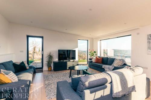 a living room with couches and a tv at Stunning 5 Bedroom New Build with Amazing Views! in Bath