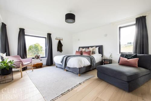 a bedroom with a bed and a couch and a chair at Stunning 5 Bedroom New Build with Amazing Views! in Bath