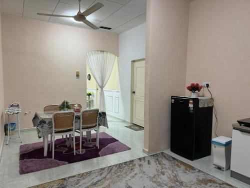 a dining room with a table and some chairs at Indah Jerai Homestay in Guar Chempedak
