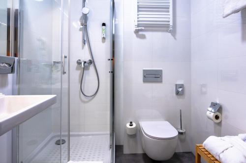 a bathroom with a shower and a toilet and a sink at Hotel MDM City Centre in Warsaw