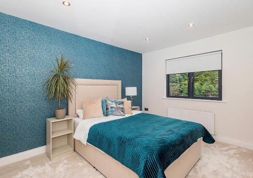a bedroom with a bed with a blue wall at Malahide Castle Hideaway in Malahide