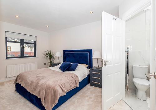 a bedroom with a blue bed and a toilet at Malahide Castle Hideaway in Malahide