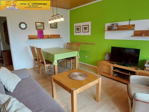 a living room with a table and a green wall at Apartment Urlaubstraum in Bad Mitterndorf