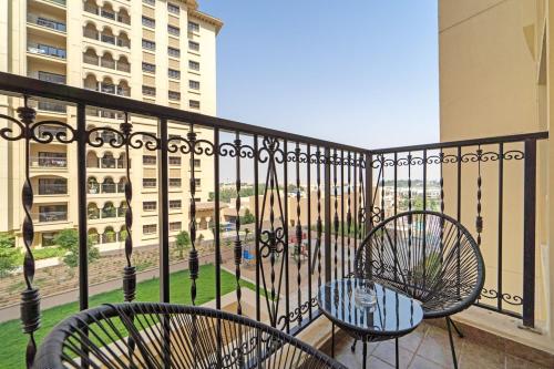 a balcony with two chairs and a table at Free housekeeping visits during your stay - StayShort - Restful 1-Bedroom Apartment at Al Andalus in Jumeirah Golf Estates in Dubai