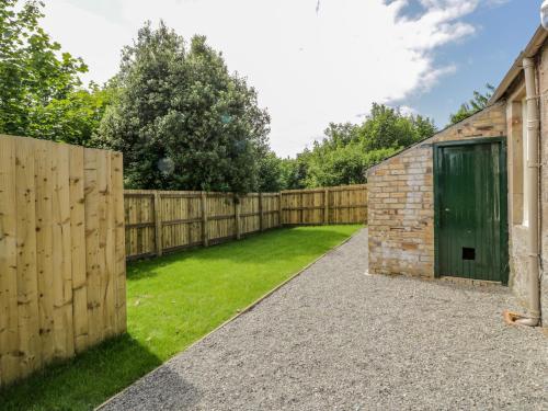 a garden with a wooden fence and a shed at North Firbank - Culzean Castle in Maybole