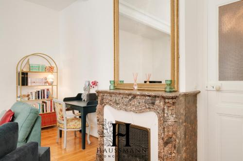 - un salon avec une cheminée et un miroir au-dessus dans l'établissement Magnifique Appartement Luxe Cœur de Nancy, à Nancy