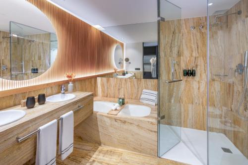 a bathroom with two sinks and a shower at Hotel Meliá Bilbao in Bilbao