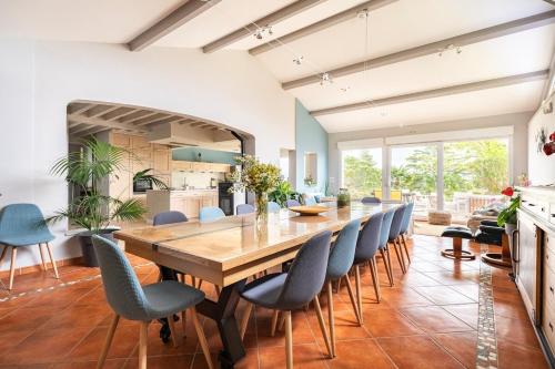 une salle à manger avec une grande table et des chaises en bois dans l'établissement La Villa Moursoise 4 Etoiles, à Mours-Saint-EusÃ¨be