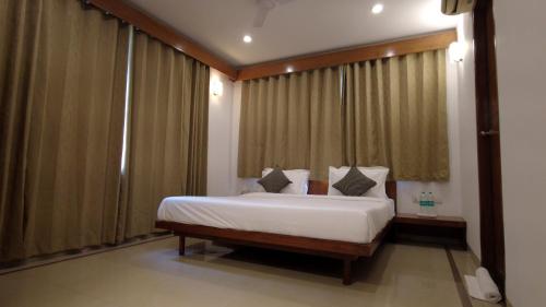 a bedroom with a large bed with curtains at Arogyadham Swasthya Kutir in Chitrakoot