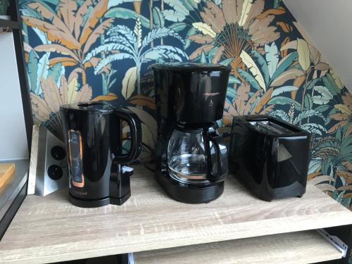 trois cafetières noires assises sur une étagère dans l'établissement Le 2ème étage de Manon, à Phalempin