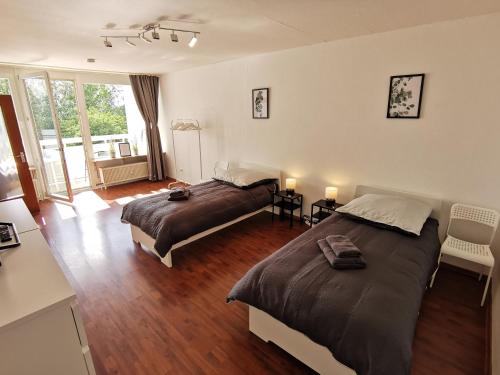 a bedroom with two beds and a balcony at FR14 - Schöne 2-Zimmer-Wohnung mit Balkon in Heusenstamm in Heusenstamm