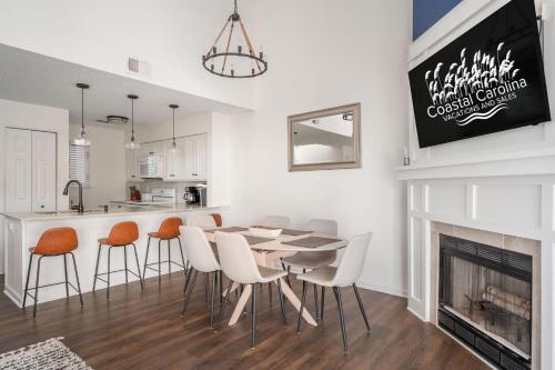 a dining room with a table and chairs and a fireplace at PCBV325 Anchor's Away in Manteo