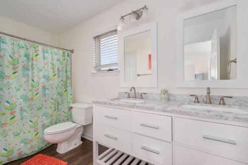 a bathroom with a toilet and a sink and a mirror at PCBV325 Anchor's Away in Manteo