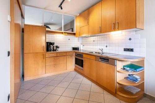 a kitchen with wooden cabinets and a sink at Ferienwohnung Hans in Prato allo Stelvio