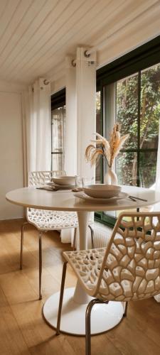 une salle à manger blanche avec une table et des chaises dans l'établissement Maisonnette avec jardin - proche Paris - Disney, à Gagny
