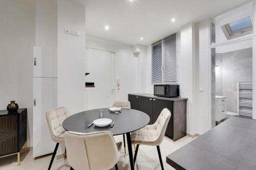 une cuisine et une salle à manger avec une table et des chaises dans l'établissement ODERNER - Cosy apartment, à Paris