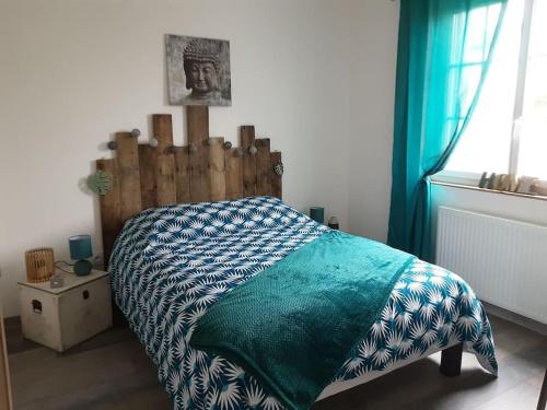 un lit avec une tête de lit en bois dans une chambre dans l'établissement Maison individuelle entièrement refaite, à La Ferté-Bernard