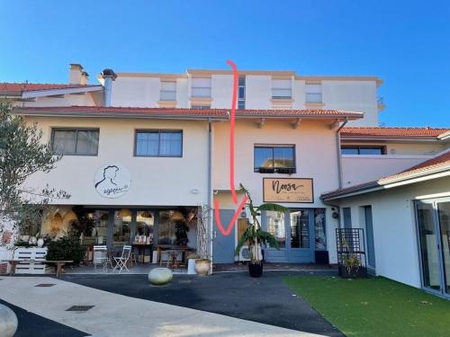 un bâtiment avec un ruban rouge devant lui dans l'établissement Agréable 3 chambres extra centre à 200m de l'océan, à Biscarrosse