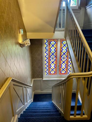 a staircase with a stained glass window in a building at Hôtel le Manoir du Soldat in Phalsbourg