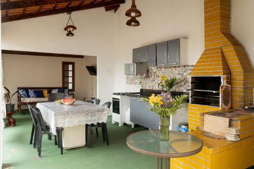 a kitchen with a table and a dining room at Cerrado 07 - Suítes individuais em pousada in Pirenópolis