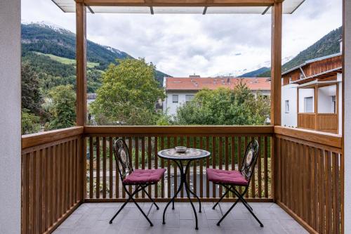 a patio with a table and two chairs on a balcony at Ferienwohnung Hans in Prato allo Stelvio