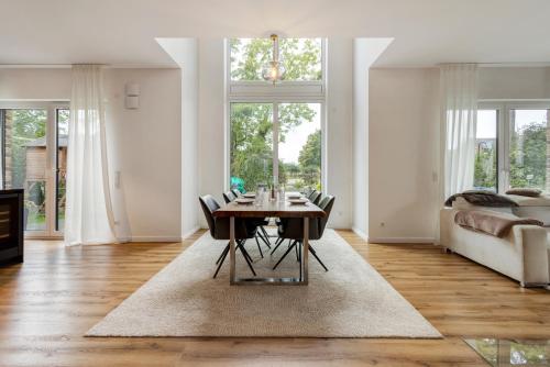 a living room with a table and chairs and a couch at Luxurious Family House in Tornesch