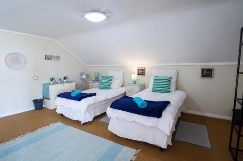 a room with two beds with blue pillows in it at Harbour Lights in Velddrif