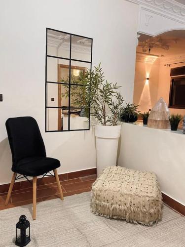 a chair and a ottoman in a room with a mirror at Charming app 3 min Sania Ramel AIRPORT Tetuan in Tetouan