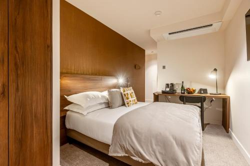 une chambre avec un lit avec une tête de lit en bois dans l'établissement Le Madame By Sweett, à Paris