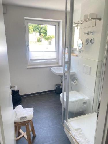a bathroom with a sink and a toilet and a window at Motel Q- das kleine Stadthotel in Dingolfing