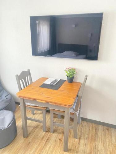 a wooden table with two chairs and a potted plant on it at Motel Q- das kleine Stadthotel in Dingolfing