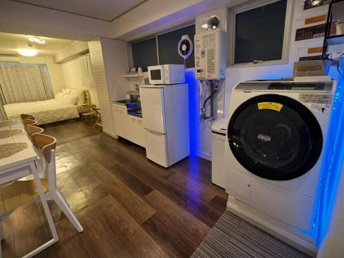 a kitchen with a washing machine in a room at Elena Shinsaibashi Stay in Osaka