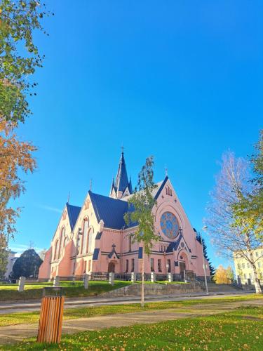 a pink church with a steeple on a clear day at 20 - Nice apartment in Kemi City Centre, free parking! in Kemi