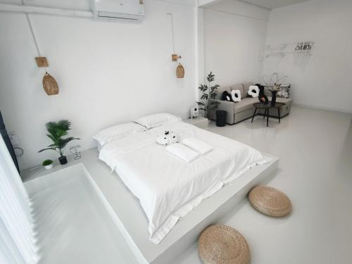 a white bedroom with a white bed with two stuffed animals on it at Fivehouse Silom1 - City heart - Silom -BTS MRT 2min - lumpini park - bnh in Bangkok