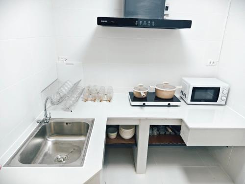 a white kitchen with a sink and a microwave at Fivehouse Silom1 - City heart - Silom -BTS MRT 2min - lumpini park - bnh in Bangkok