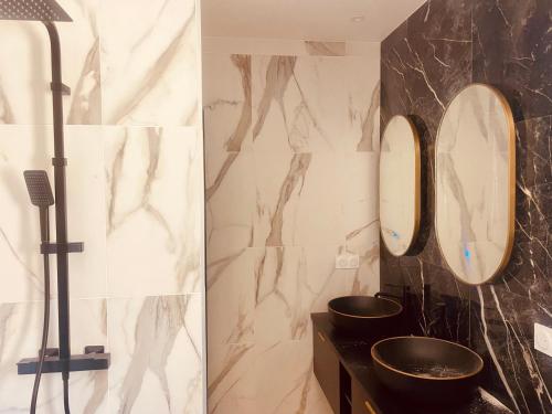 a bathroom with two sinks and two mirrors at Villa Casa Damicella Bord de Mer avec Piscine in Palasca